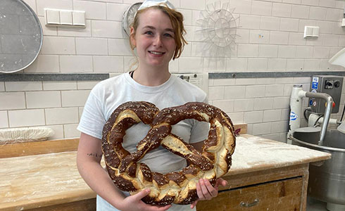 Unsere Auszubildende Ronja mit einer Riesenbreze in der Hand